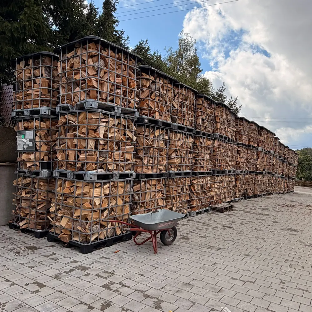 Gestapelte Brennholz-Gitterboxen auf dem Hof